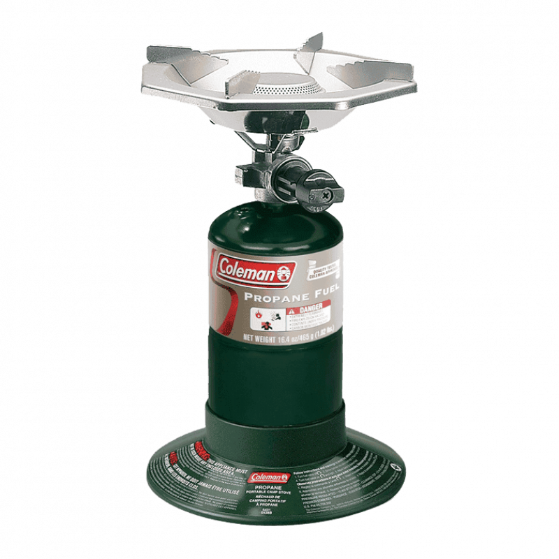 Portable Coleman camping stove with burner on green propane canister for outdoor cooking.